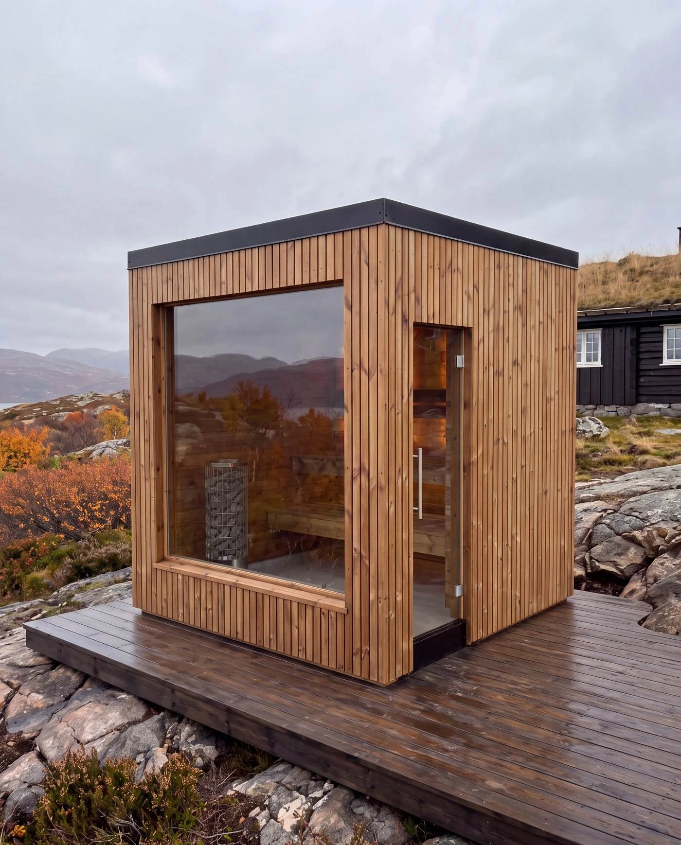 The Cube beside a traditional mountain cabin in autumn